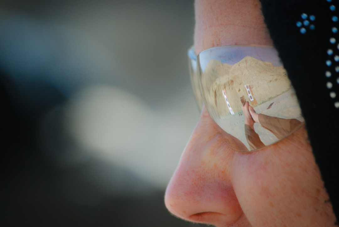 A Afghani female security agent at the firearms range. The reflection of her pistol and the target are reflected in her eye protection. Photographed by 8d Photos based in Clermont, Florida, USA.