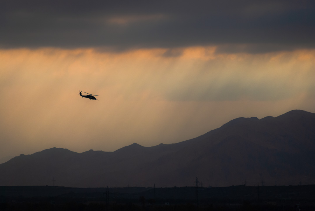 A UH-60 Blackhawk helicopter is sillouetted against the stormy skys in Kabul, Afghanistan. Photographed by 8d Photos based in Clermont, Florida, USA.